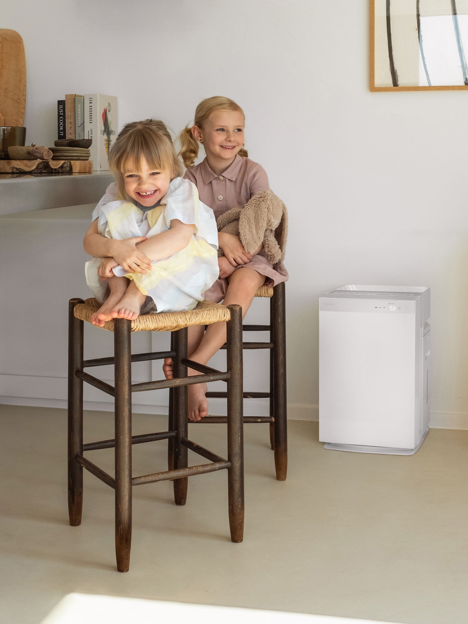 Deux jeunes sœurs assises sur les tabourets de la cuisine et riant