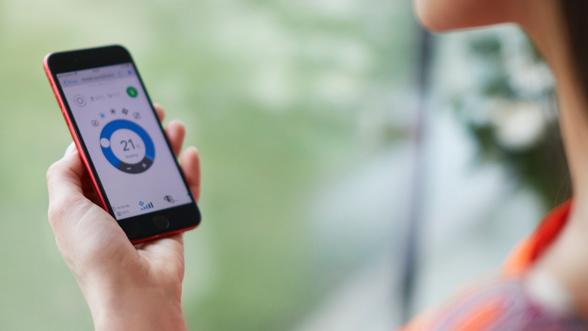 Vrouw die haar verwarmingsoplossing regelt met een app