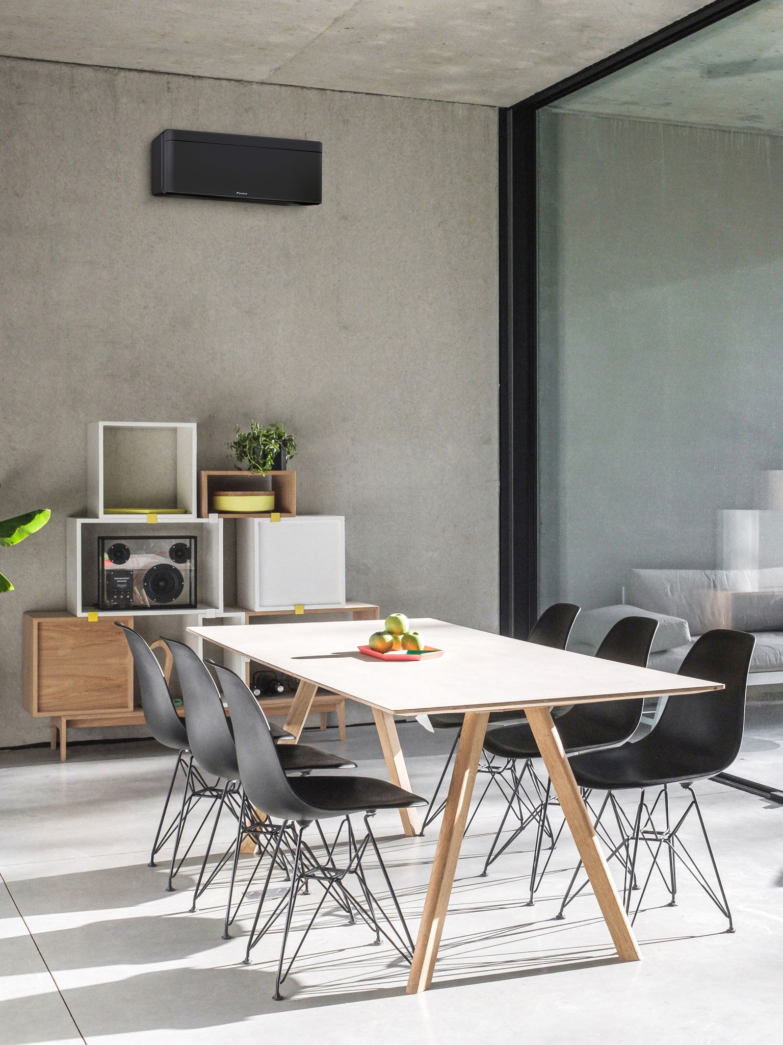 Eetkamer met een groot raam en een lucht-luchtwarmtepomp aan de wand gemonteerd