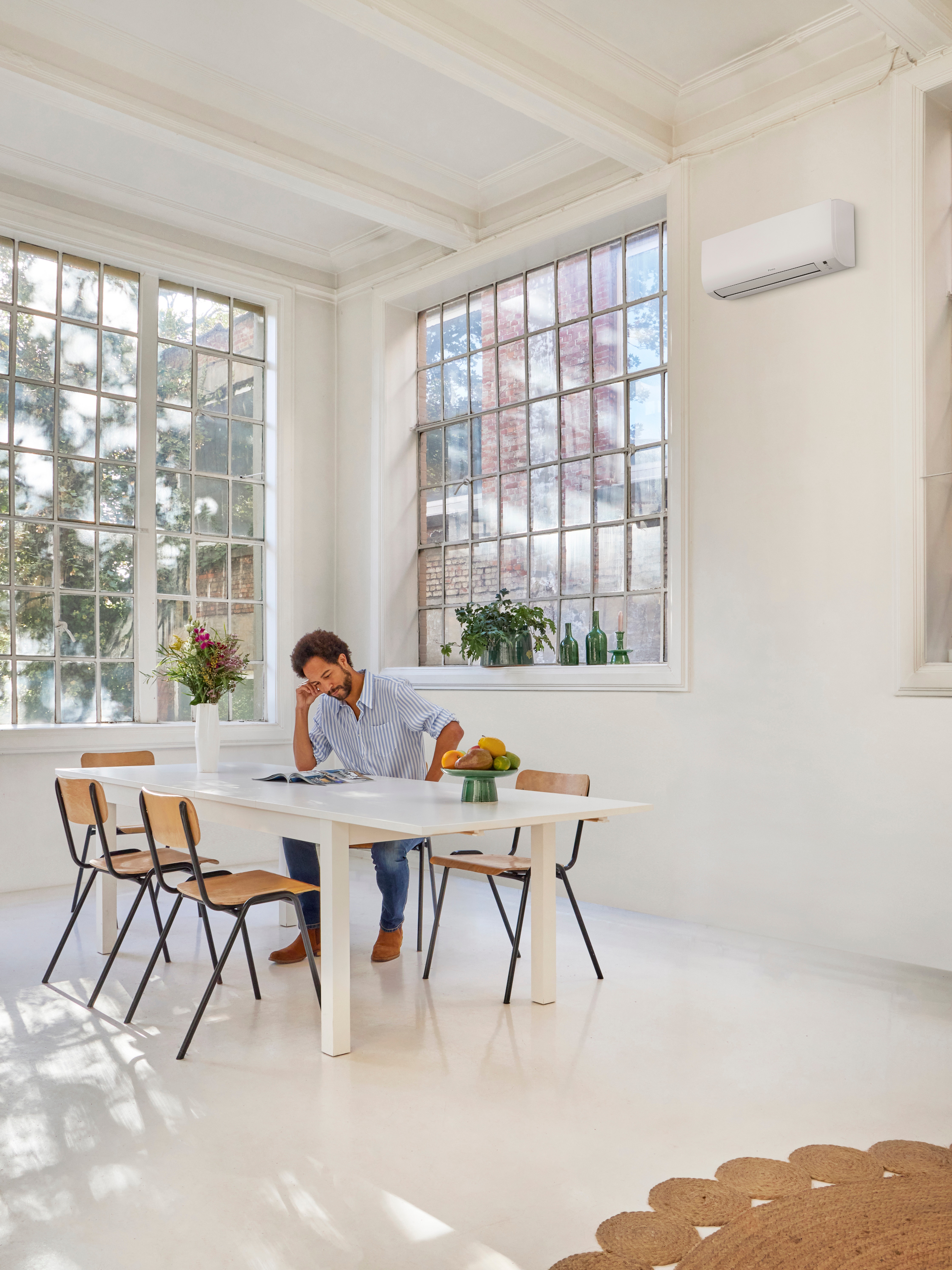 Homme lisant à table tout en profitant de la température parfaite à l'intérieur de son logement