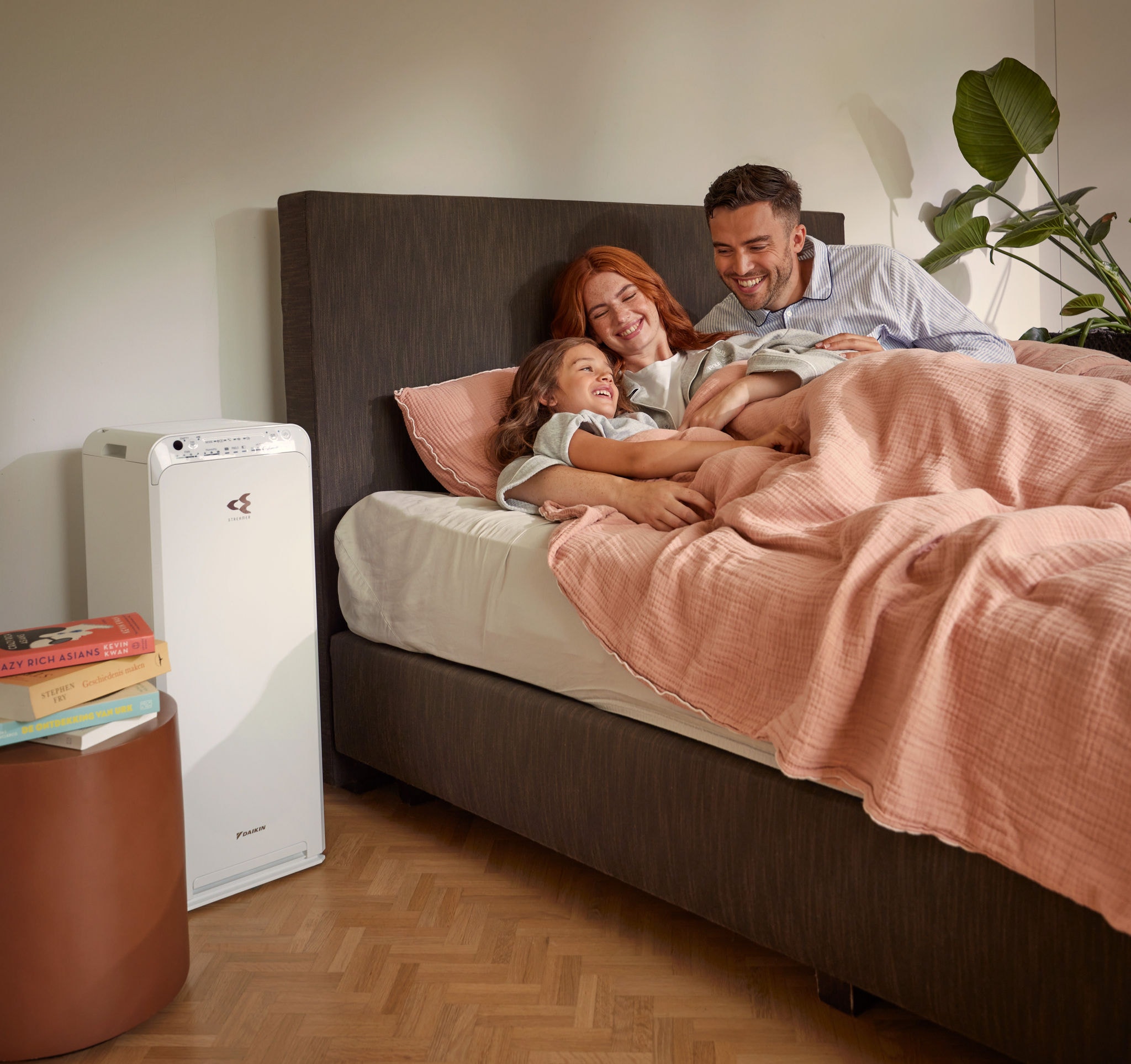 Koppel met kind ontspant zich in slaapkamer genietend van schone lucht met luchtreiniger