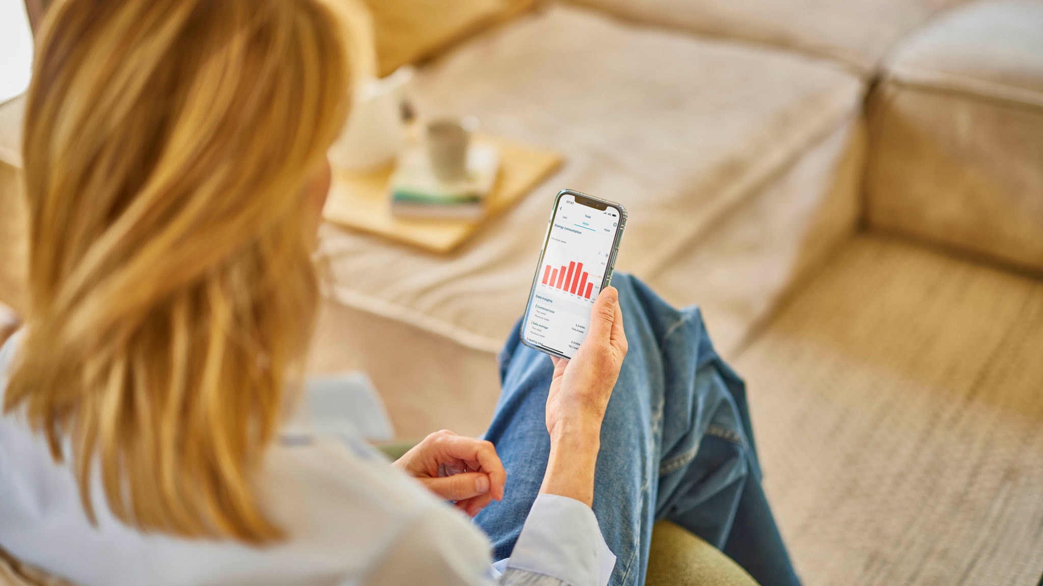 Vrouw bedient haar ventilatie-unit met de Onecta-app