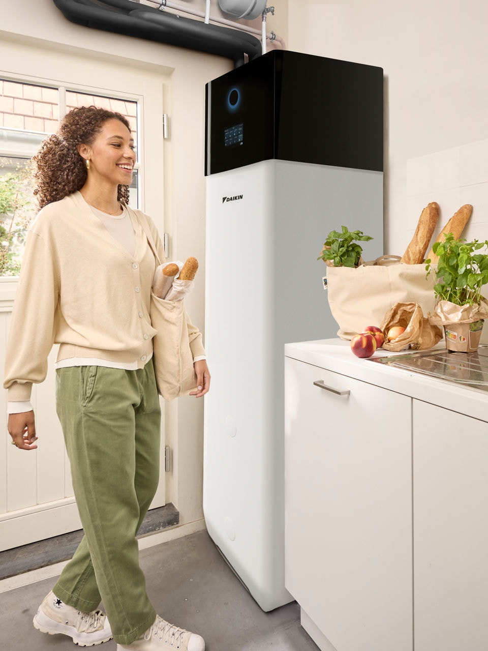 Vrouw die boodschappen heeft gedaan en thuiskomt met de boodschappentassen in haar handen