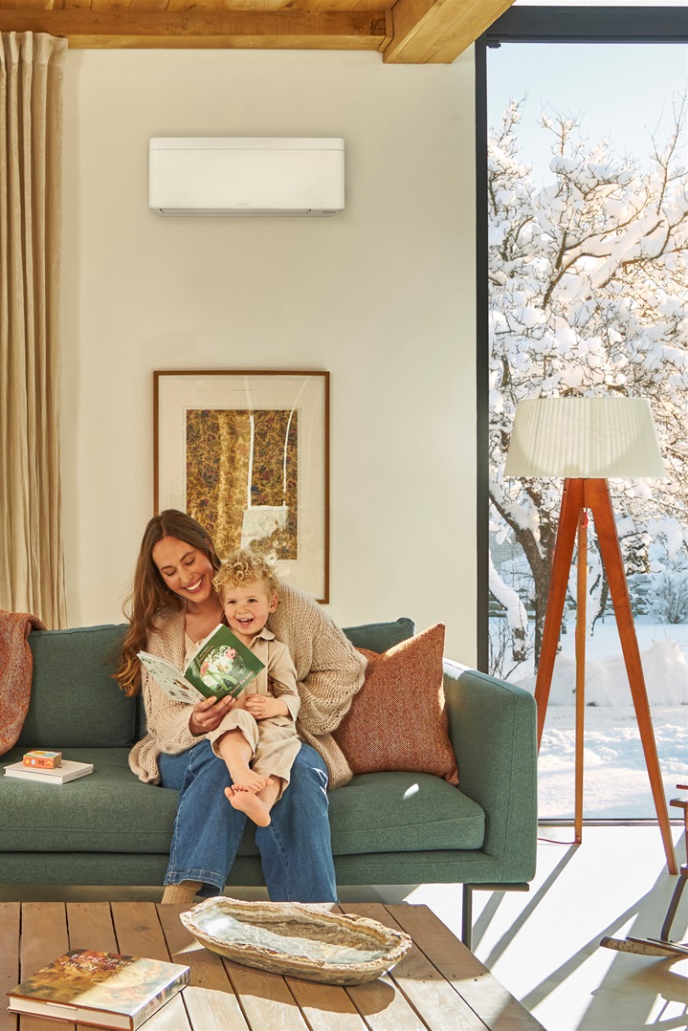 Moeder en kind lezen een boek op de bank bij een comfortabele temperatuur
