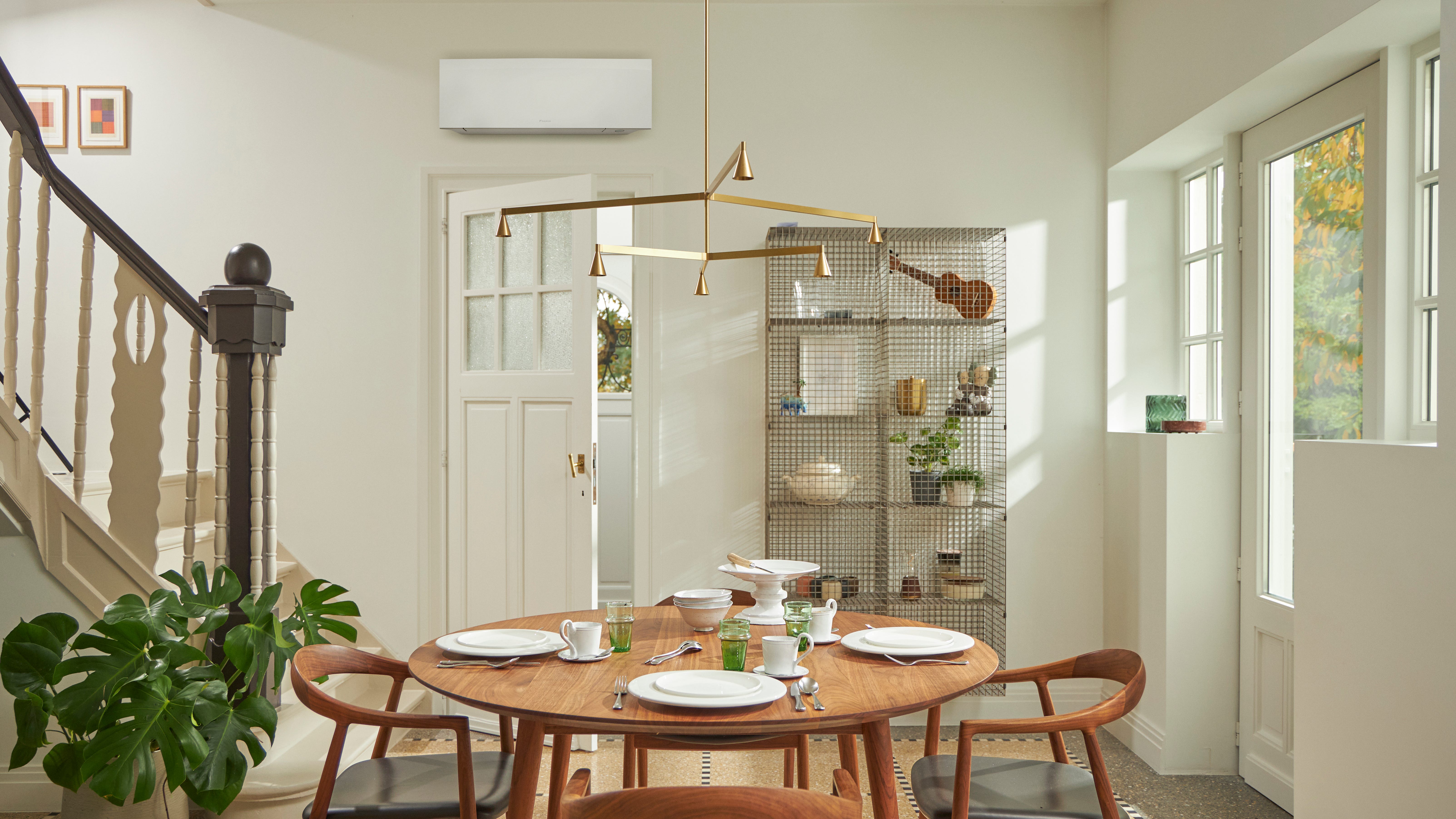 Pièce avec une grande fenêtre, une table en bois et une solution de climatisation murale noire