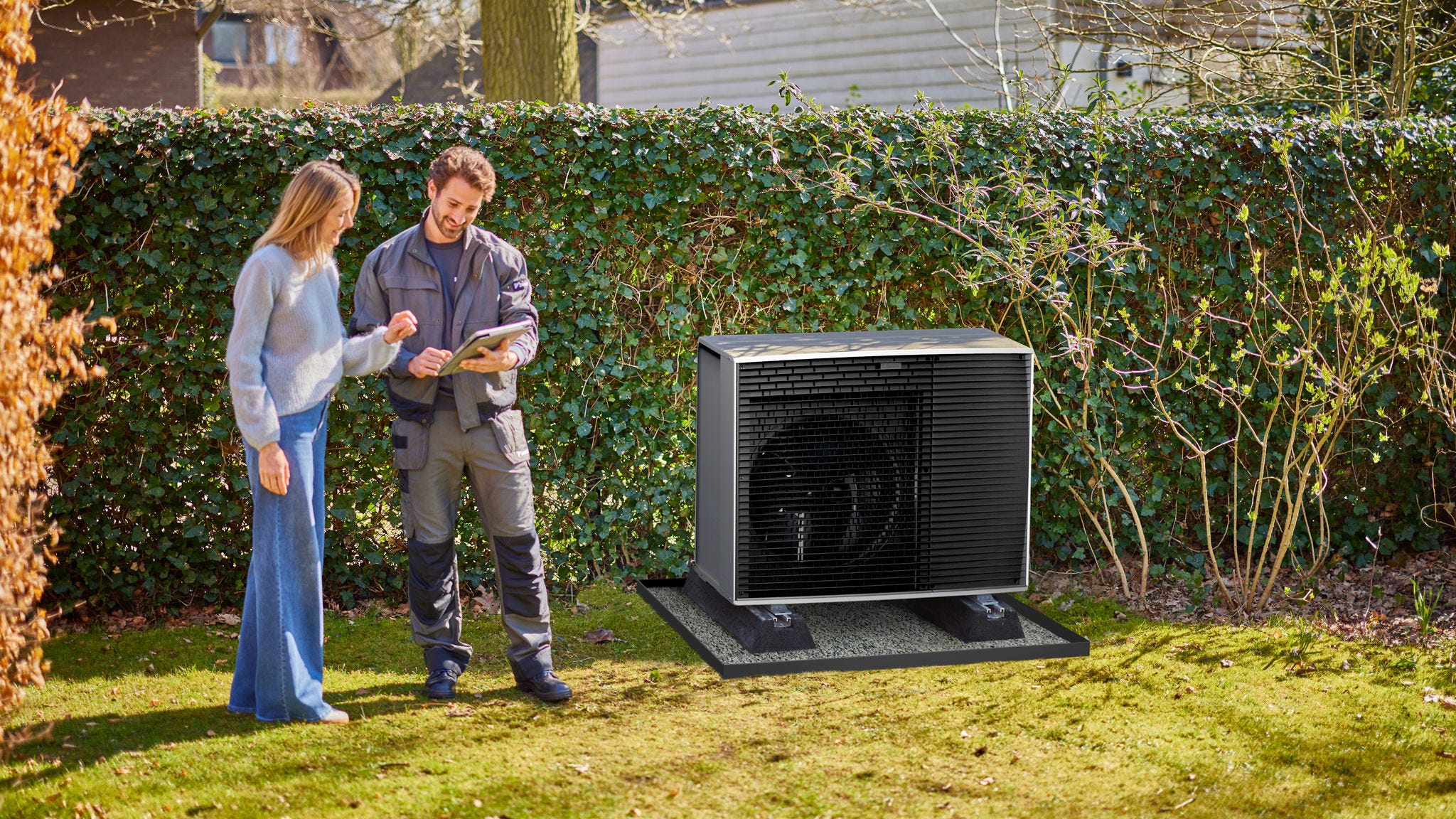 Buitenunitinstallatie van een lucht-waterwarmtepomp in de tuin bij een woning