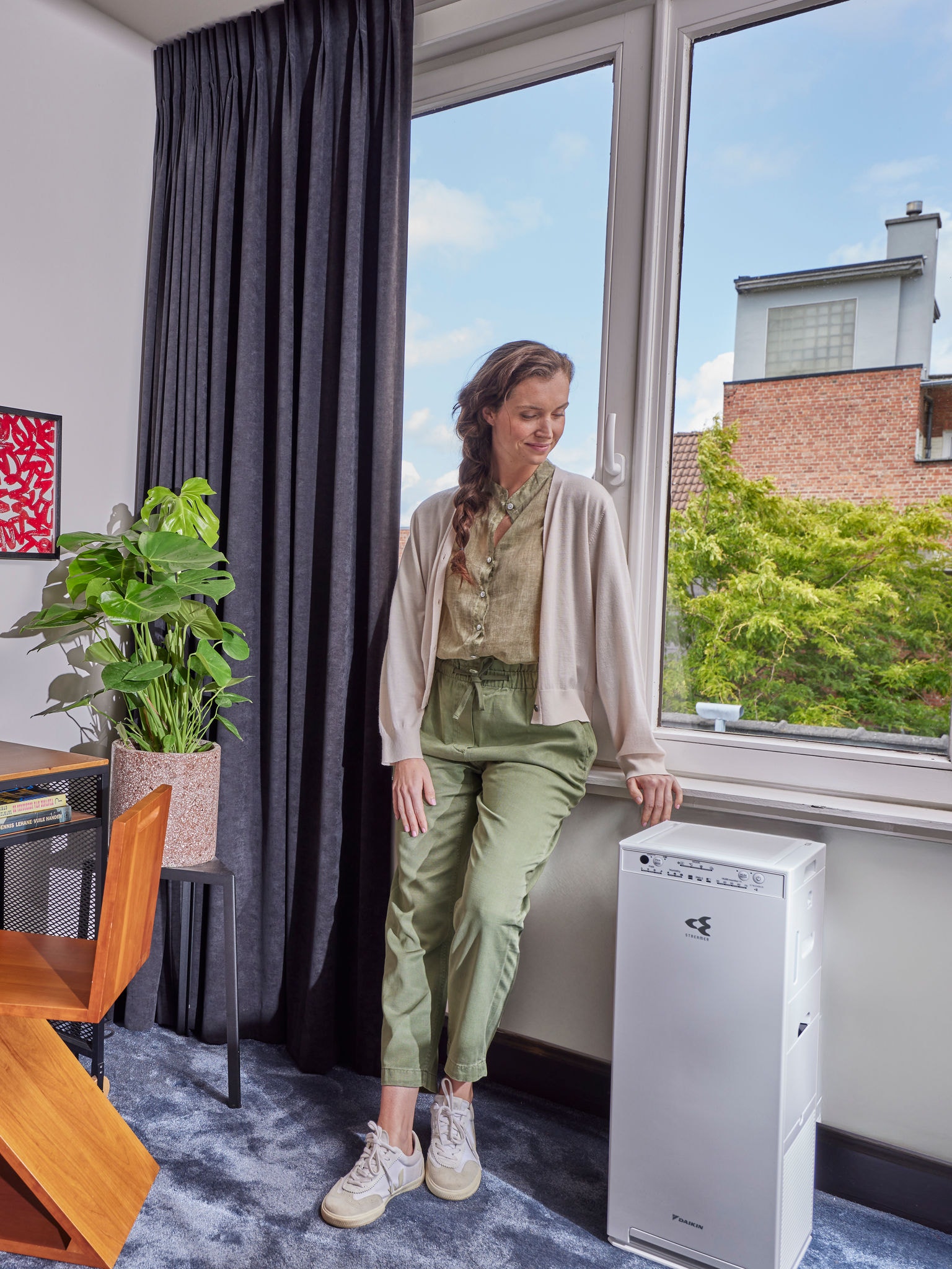 Vrouw die naast haar luchtreiniger staat