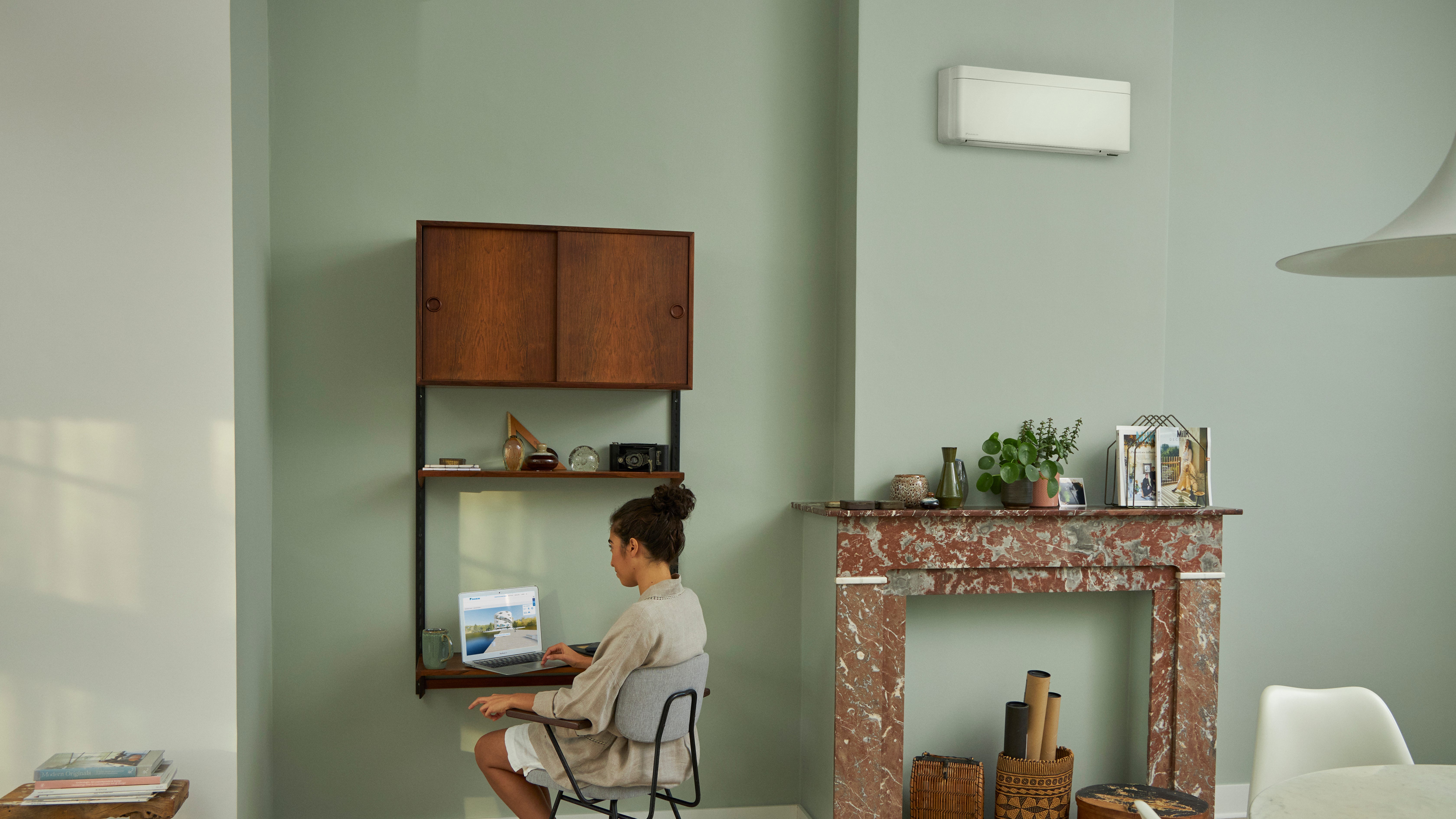 Visite du showroom virtuelle Daikin via un ordinateur portable installé sur un petit bureau dans un salon joliment décoré.